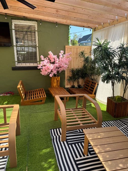 A cozy garden seating corner at The Patio with pink flowers and lounge chairs
